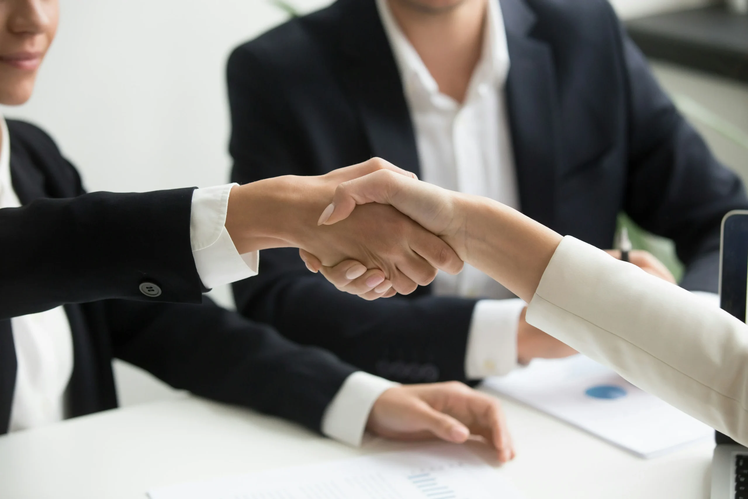 Professionals shaking hands during an HMRC settlement and penalty mitigation meeting
